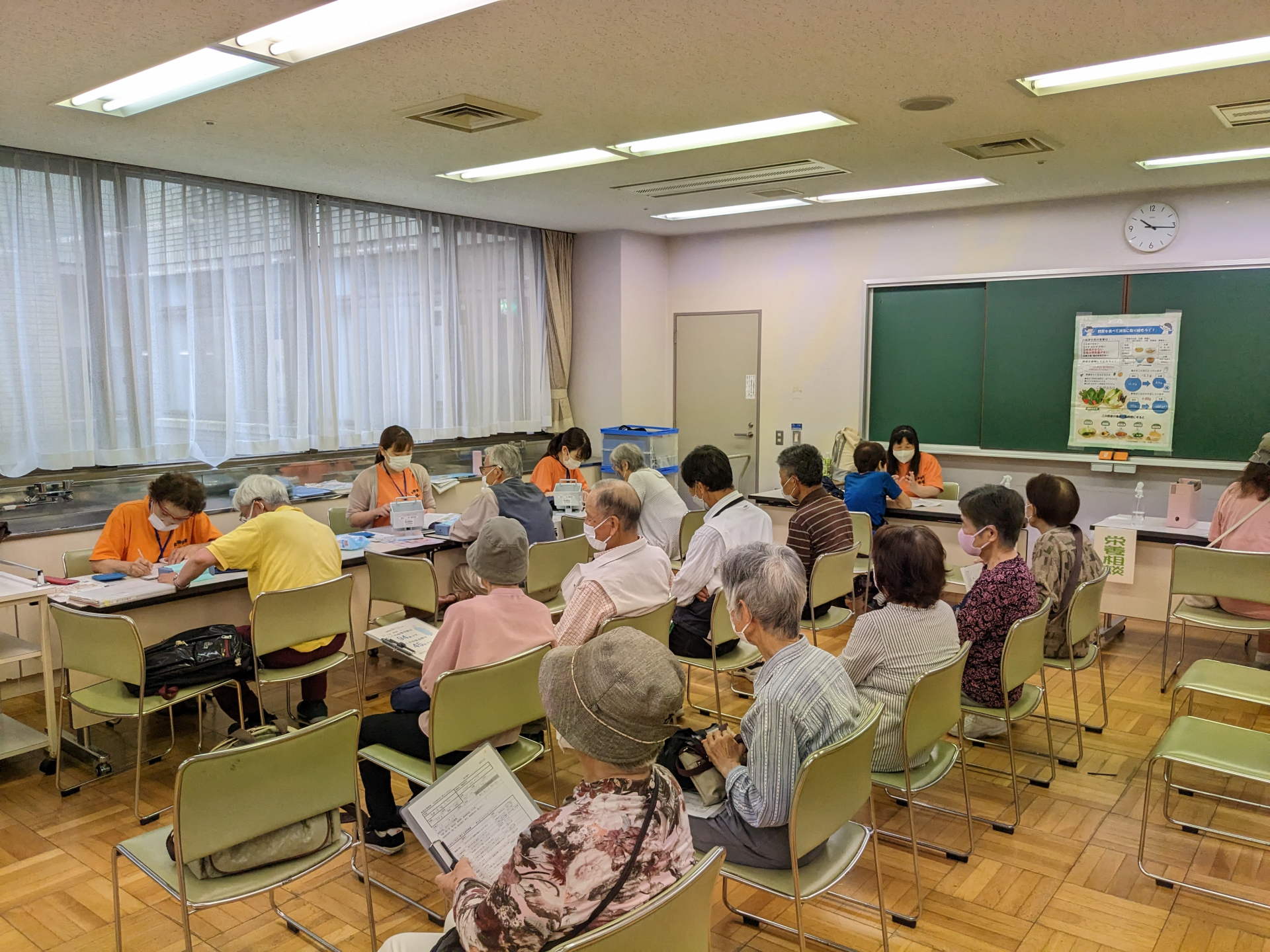 保健師による血圧測定と健康相談をしている様子。