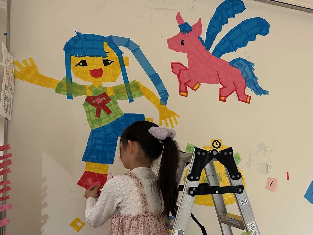 カラーテープを壁に貼る参加者