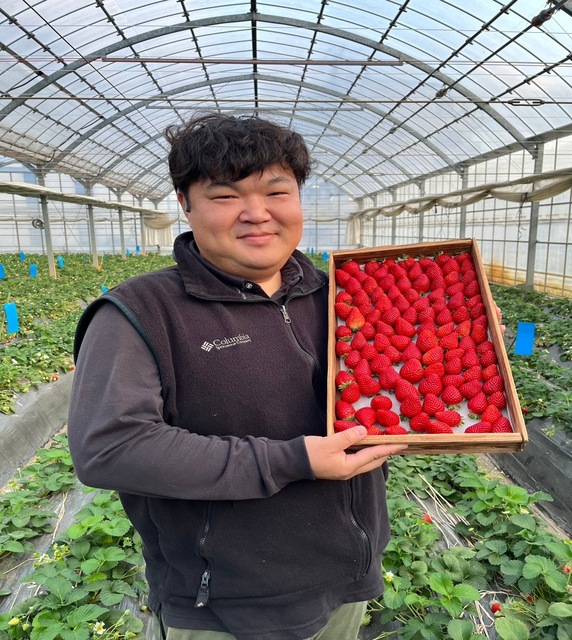 いちご生産者の写真（いちごを持っている）