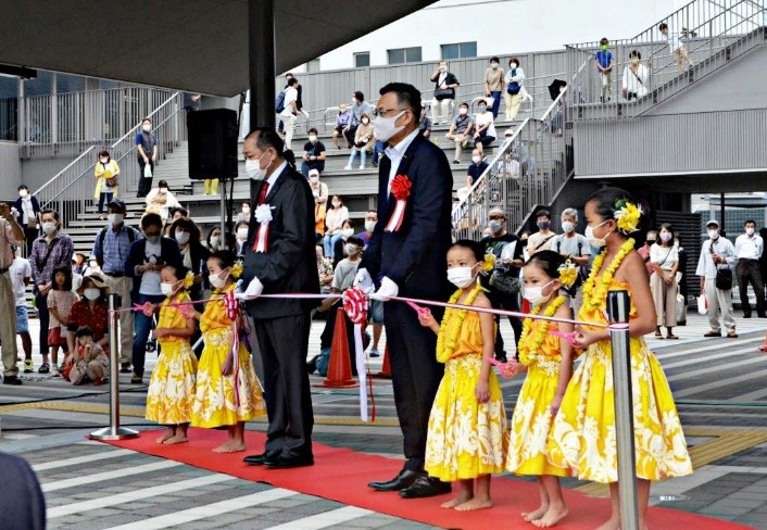 （写真４）フラダンスの少女たちとテープカット