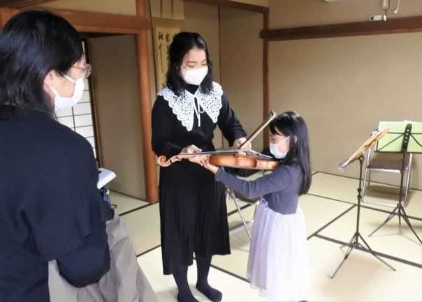 （写真10）女の子にヴァイオリンを指導