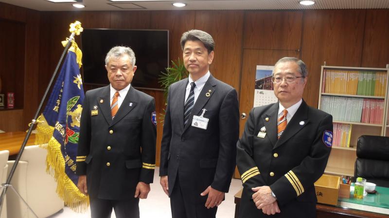 市消防団の任命式にて、前団長の中村さん、新団長の神尾さんらと