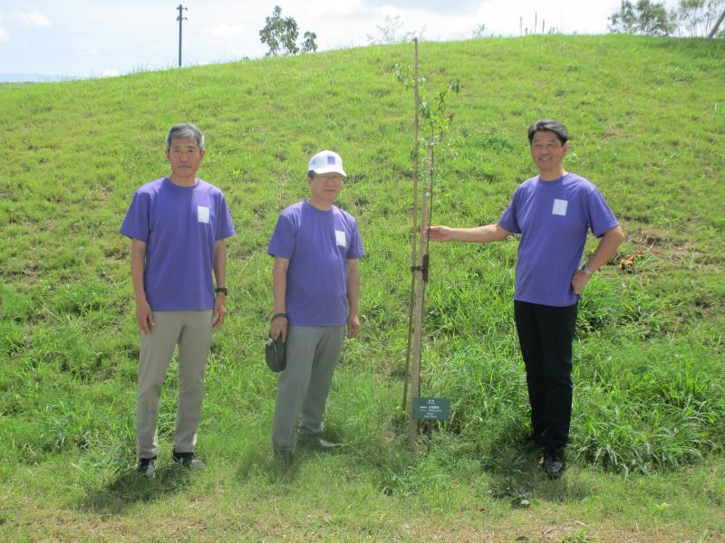 「桑都の杜」に小田原庭園業組合が植樹したおかめ桜を背に