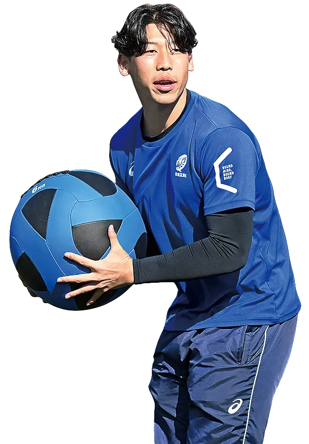 吉田将人コーチが青いユニフォームでメディシンボールを抱える様子