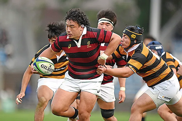 早稲田大学の試合でボールを持って走る選手とタックルする相手選手