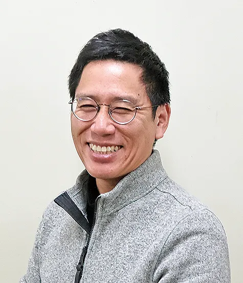 高島さんのポートレート写真（グレーのジャケット）