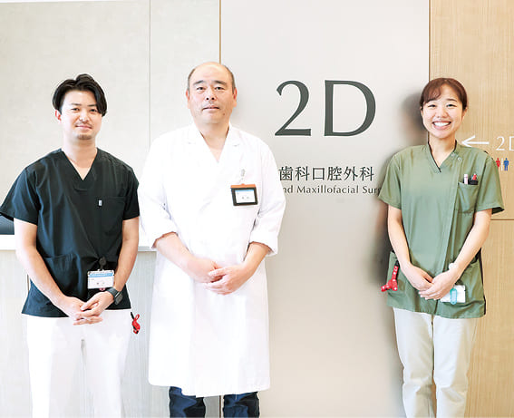 歯科口腔外科の入り口前に並ぶ医師と歯科衛生士