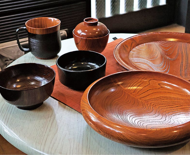 大川さんが制作した小田原漆器。黒とあずき色の椀、丸盆、小皿が並ぶ