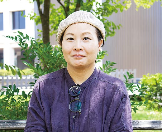 紫の作務衣姿で工房に立つ鈴木さん