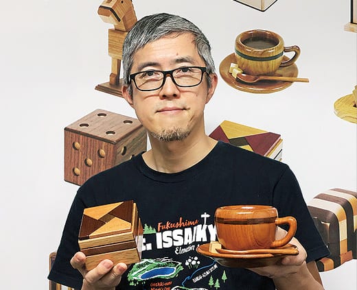 秘密箱と木製ティーカップを持つ岩原さん