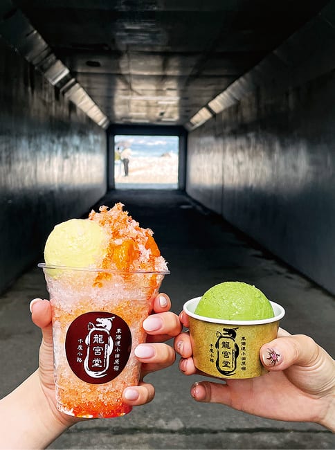 海へと続くトンネルの中で、2つのかき氷を持つ手元