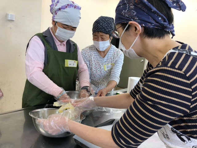 講師　山口氏（手前）を手本に、クッキー生地を混ぜる様子