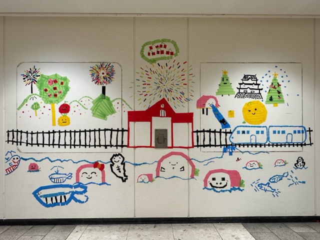 完成した壁の一部（小田原駅周辺の四季を子供がカラーテープで作成したもの）