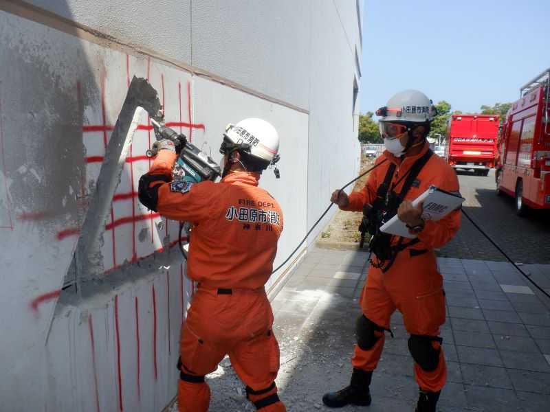 座屈耐火建物等への進入、退出路を確保するため、鉄筋コンクリート等を破壊する技術（ブリーチング）をしている写真