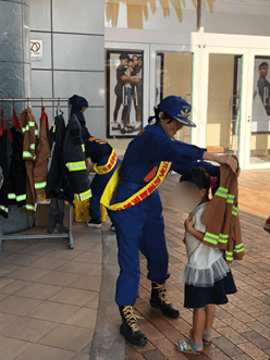 秋火災予防において参加している子供が防火服を着る体験をしている様子