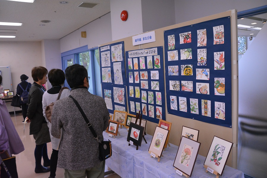 第一講習室　イベントを訪れた人達が絵手紙の展示を見ている