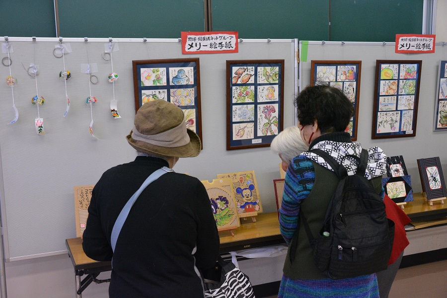 第一講習室・イベントを訪れた人達が絵手紙の展示を見ている様子　