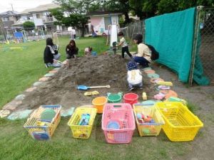 ようちえんで遊ぼうで親子で砂遊びをしている様子