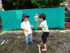 トンボを捕まえた男の子が嬉しくて友達に見せている様子