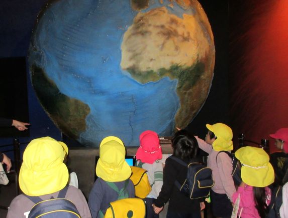 大きな地球儀の前で見学をしているところ