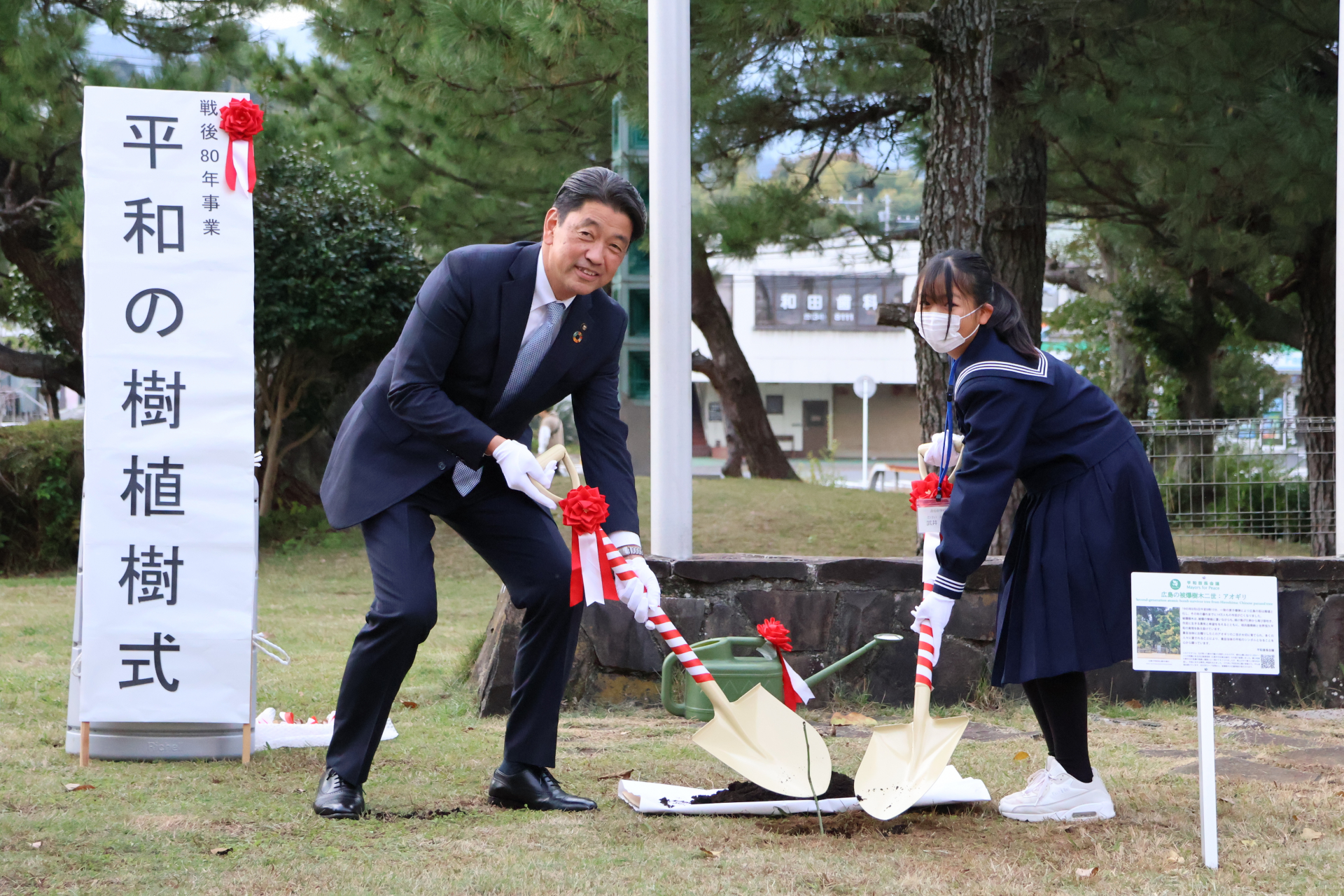 加藤市長と代表生徒の土かけの様子