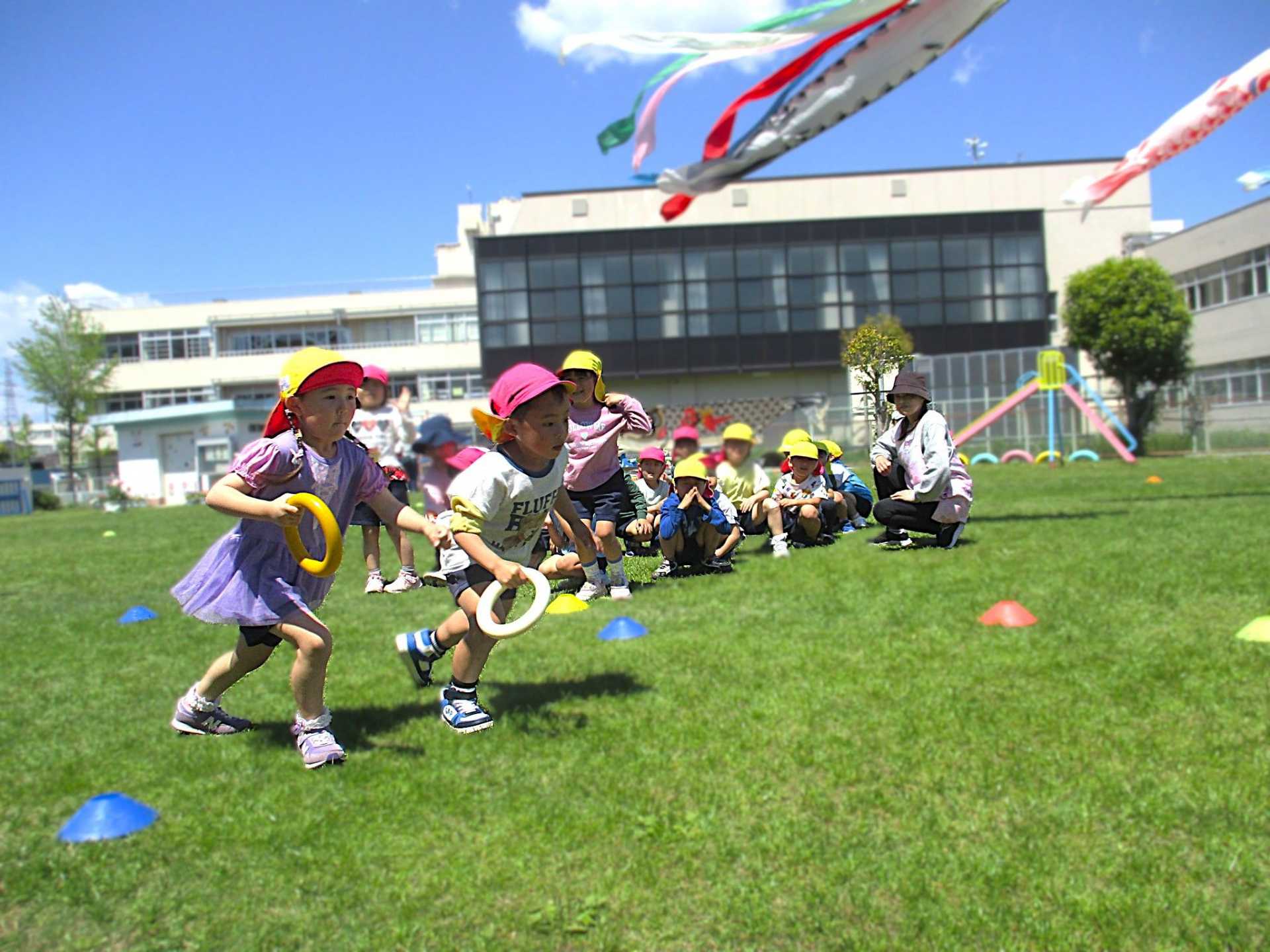 園庭で園児がリレーをしている写真