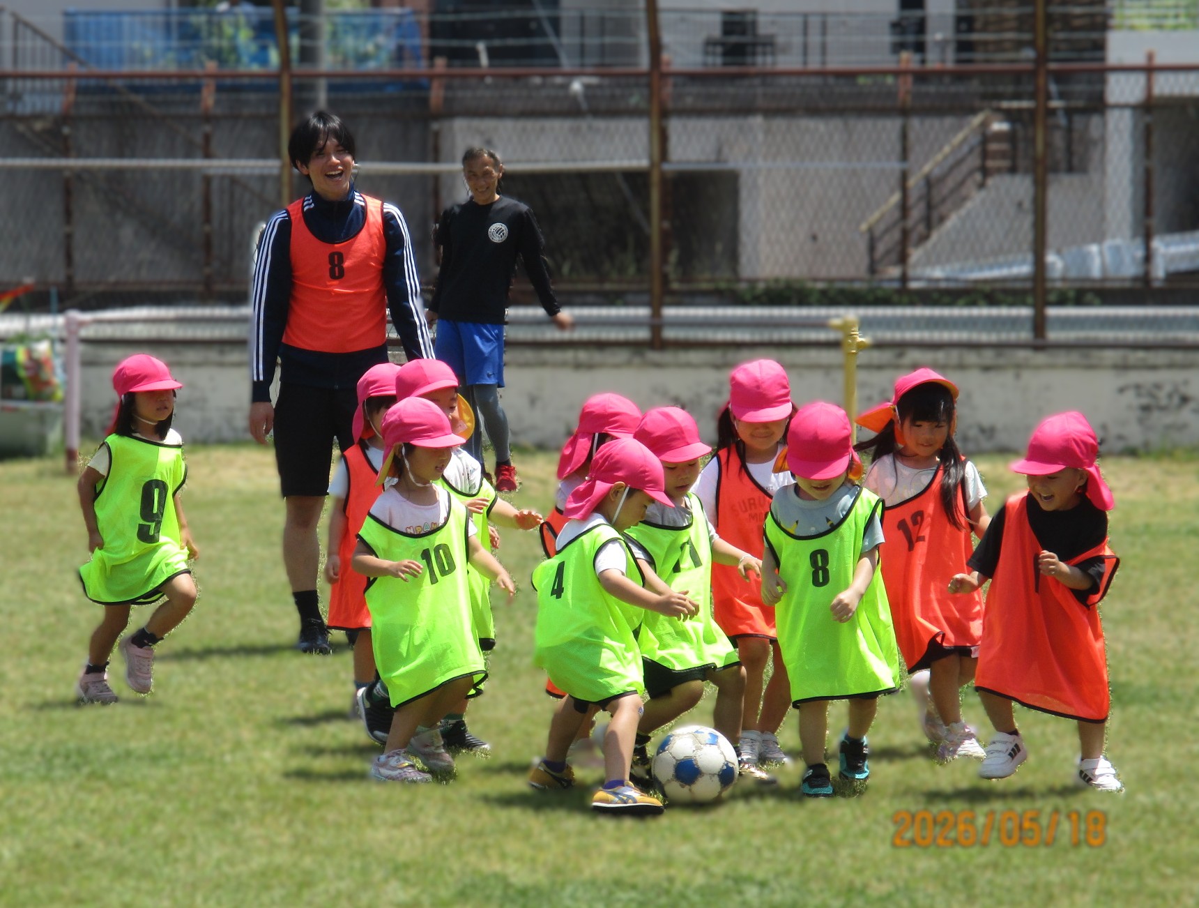 園庭で園児がサッカーをしている写真