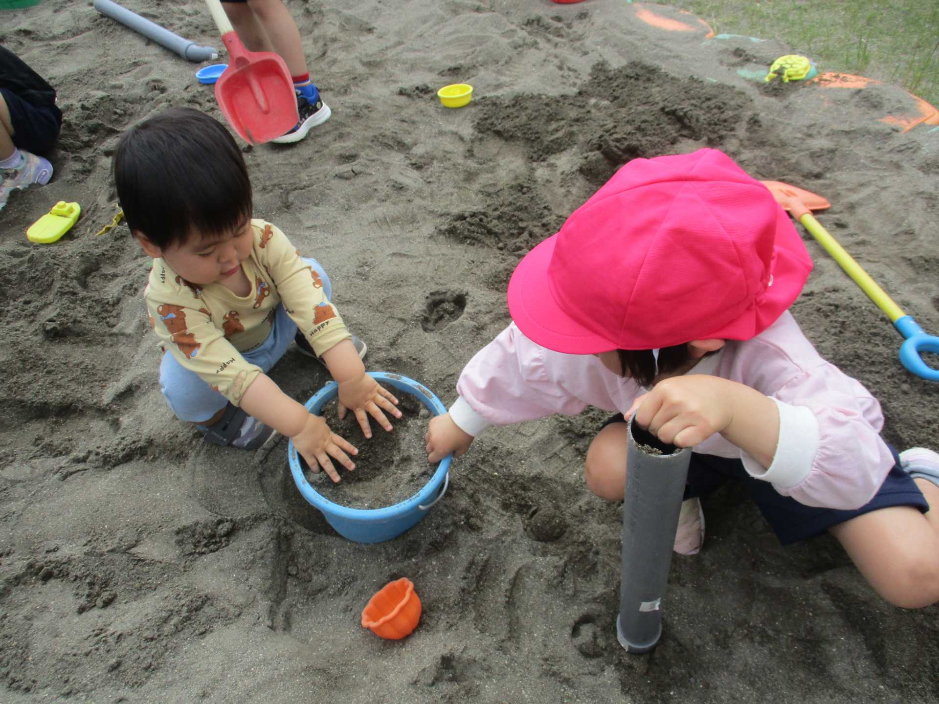 未就園児が園児と砂場遊びをしているところ