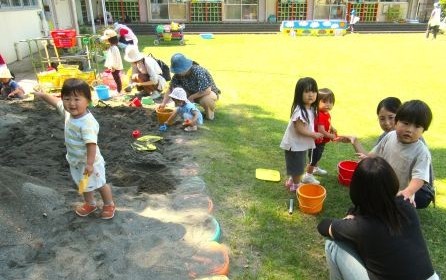 砂場で親子で遊んでいる様子