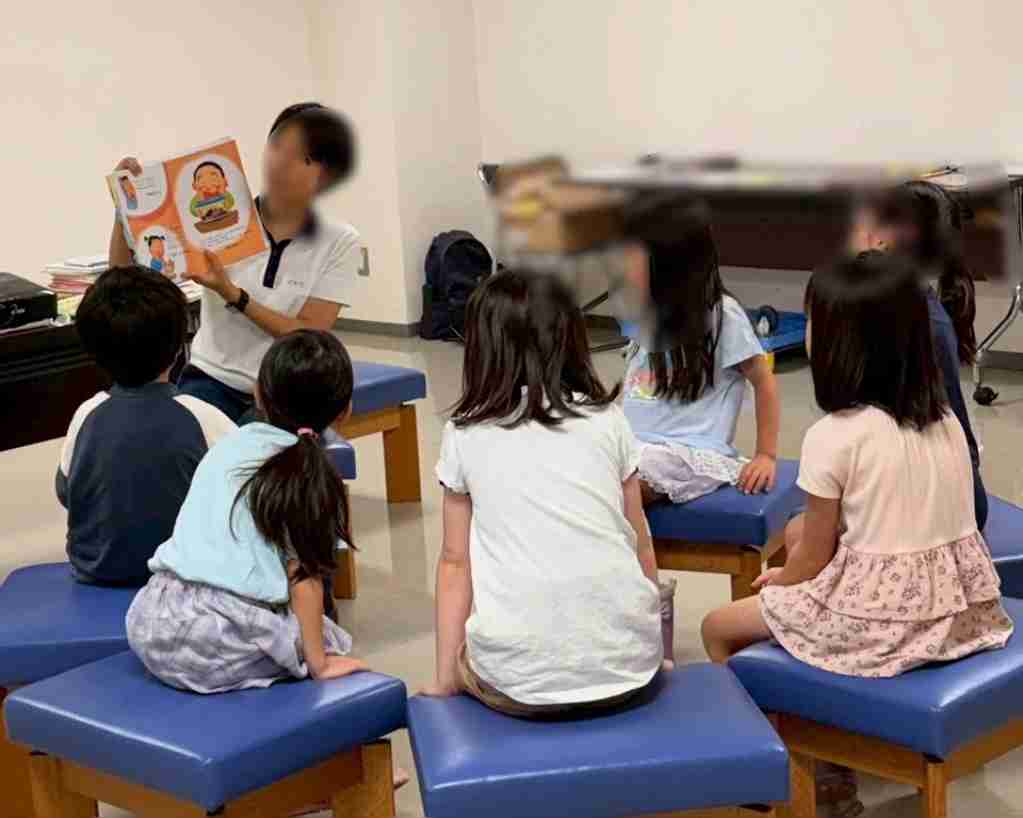 初めて会うお友達と一緒に先生の話を聞いている