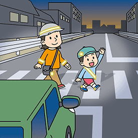 暗い横断歩道を反射材を着用して横断する親子の画像