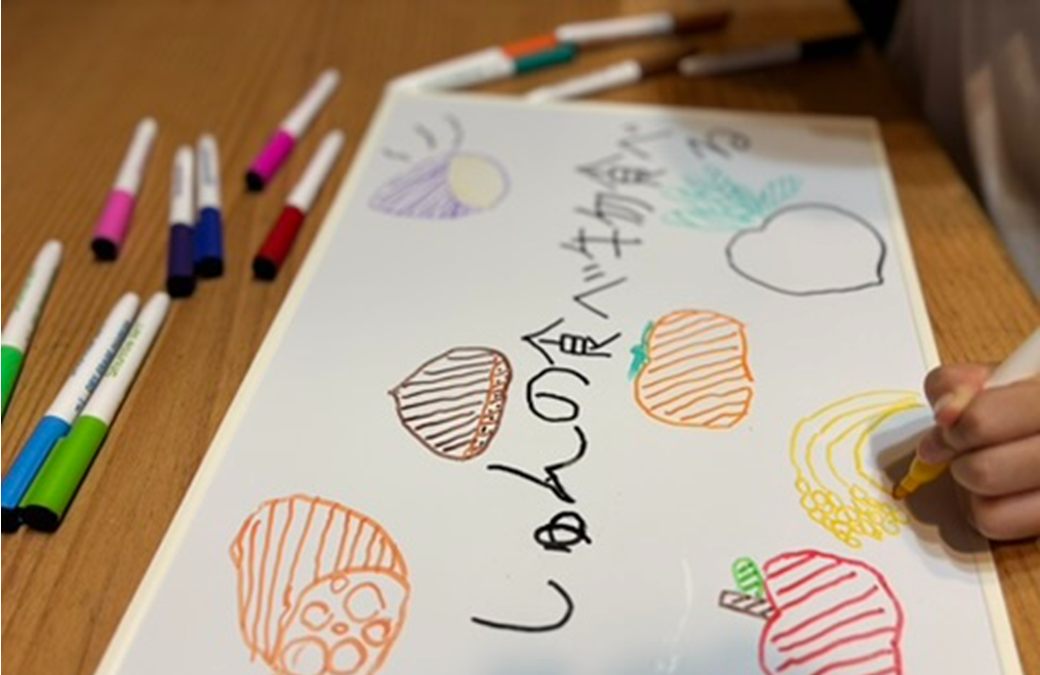 ホワイトボードにゼロカーボン行動を描いている様子です。